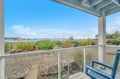 Sip morning coffee on your private balcony while watching sailboats drift across tranquil waters and coastal grasses sway in the breeze.