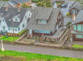 Aerial view of a charming coastal neighborhood featuring traditional shingled homes with spacious decks and mature landscaping.