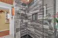 Step into your luxurious glass-enclosed shower featuring stunning marble-inspired tile walls and rainfall showerhead for ultimate relaxation.