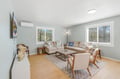 Settle into this bright, modern living space with plush seating, warm wood accents, and natural light streaming through large windows. Your perfect spot to unwind after exploring.