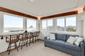 Relax on your cozy sofa while taking in stunning ocean views through panoramic windows, creating the perfect coastal retreat.