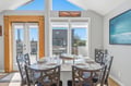 Picture yourself sharing meals here at the glass dining table, with vaulted ceilings and ocean views framing every bite, creating the perfect backdrop for your coastal getaway.
