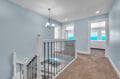 Bright upstairs landing welcomes you with soft blue walls and glimpses of stunning ocean views through nearby bedrooms.
