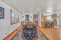Your spacious dining room flows seamlessly into the kitchen, perfect for memorable meals and conversations around the beautiful wooden table.