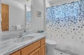 Step into your private bathroom with elegant marble countertops and cheerful blue-dotted shower curtain for refreshing morning routines.