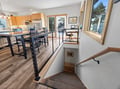 Your open-concept loft offers a seamless blend of modern kitchen, dining, and workspace with warm wood accents and natural light.