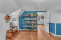 Discover your own literary retreat in this charming upstairs nook, where vibrant blue walls frame shelves of books waiting for your afternoon escape.