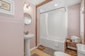 Step into your private bathroom where soft pink tones and warm wood accents create a calming retreat. Fresh towels and a spa-like atmosphere await your arrival.