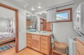 Your spacious bathroom offers warm wood accents and natural light, with convenient laundry facilities right at hand.