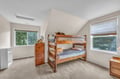 Your kids will love this cozy bunk room with sturdy wooden beds and peaceful garden views through bright windows.