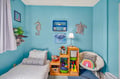 Your little ones will love this ocean-themed common area with colorful sea creature art and plenty of toy storage space.