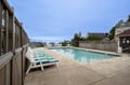 Refreshing outdoor pool area with comfortable lounge chairs and peaceful residential surroundings for your relaxing getaway.