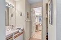 Step into your private bathroom suite, where a generous vanity and thoughtful storage await. Sunlight filters through the adjacent spaces, creating a serene sanctuary where you can start and end each day.