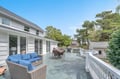 Relax on your spacious private deck with blue cushioned seating, dining area, and peaceful garden views.