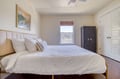Sink into crisp, plush bedding beneath the serene artwork and ceiling fan. Your peaceful bedroom opens to natural light and ample wardrobe space for effortless relaxation.