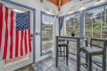 Relax in your bright sunroom with high-top seating, exposed beams, and patriotic charm—perfect for morning coffee or evening drinks.