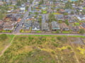 Aerial view of a quiet residential neighborhood with tree-lined streets and open green spaces nearby.