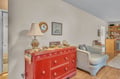 Cozy living area features charming vintage touches, with a red antique dresser and comfortable striped seating for your relaxation.