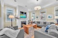 Sink into plush gray sofas while the fireplace crackles nearby, perfect for cozy evenings watching your favorite shows on the large TV.
