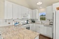 Your bright, well-equipped kitchen offers plenty of counter space and storage, with granite surfaces, modern appliances, and natural light streaming through the window for your culinary adventures.