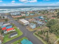 Aerial view of a charming coastal community with colorful homes and beachfront access just steps away.