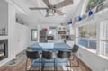 Gather around the sleek island for morning coffee or evening conversations in this stylish kitchen with exposed beams and natural light.