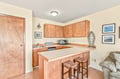 Your coastal retreat features a welcoming kitchen with warm wood cabinetry, a breakfast bar perfect for morning coffee, and ocean-inspired decor that brings the seaside right into your home.