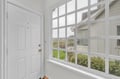 Bright enclosed porch with expansive windows frames countryside views, creating your perfect morning coffee spot.