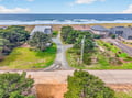 Beachfront property with direct ocean access, surrounded by coastal homes and natural vegetation just steps from pristine sandy shores.