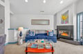 Relax by the crackling fireplace in this stylish living room featuring nautical touches and comfortable seating for your coastal getaway.