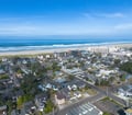 Aerial view of a charming beachside neighborhood nestled between residential streets and the stunning Oregon coast, offering easy access to miles of sandy shoreline.