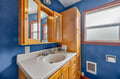 Unwind in your private bathroom featuring warm wood cabinetry and vibrant blue walls that create a cozy, nautical-inspired retreat.