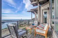 Unwind on your private balcony with stunning coastal views, where comfortable seating and ocean breezes create the perfect retreat.