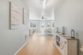 Soak in the natural light and airy feel of this open living space, where warm wood floors meet soft coastal tones. Your dining area flows seamlessly toward bright windows framing peaceful outdoor views.