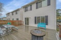 Modern duplex featuring spacious deck with seating and fire pit table for relaxing evenings.
