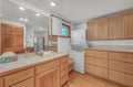 Your spacious bathroom features warm wood cabinetry, ample storage, and in-unit laundry convenience for a truly comfortable stay.
