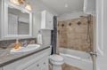 Unwind in your elegantly appointed bathroom featuring marble countertops, designer tilework, and a relaxing tub-shower combination for your comfort.