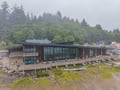 Modern beachfront property nestled between forested hillside and sandy shore, offering a unique coastal retreat in a peaceful natural setting.