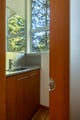 Step into your stylish bathroom where warm wood vanity meets sleek fixtures, all bathed in natural light from forest views.