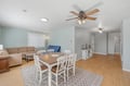Your bright open-plan space features a cozy dining table for six, a comfortable living area with soft sofas, and calming coastal colors that invite relaxation.
