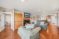 Unwind in this inviting living room where warm hardwood floors meet comfortable seating and a cozy fireplace. The open layout flows seamlessly into the kitchen, creating a perfect space for your stay.