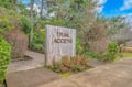 Trail access sign marks the beginning of scenic hiking paths surrounded by lush natural landscape.