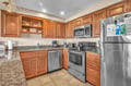 Your fully equipped kitchen features granite counters, stainless appliances, and rich wood cabinetry perfect for preparing home-cooked meals.