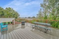 Step onto your private deck where picnic tables and cozy seating create the perfect outdoor dining spot amid peaceful treetop views.