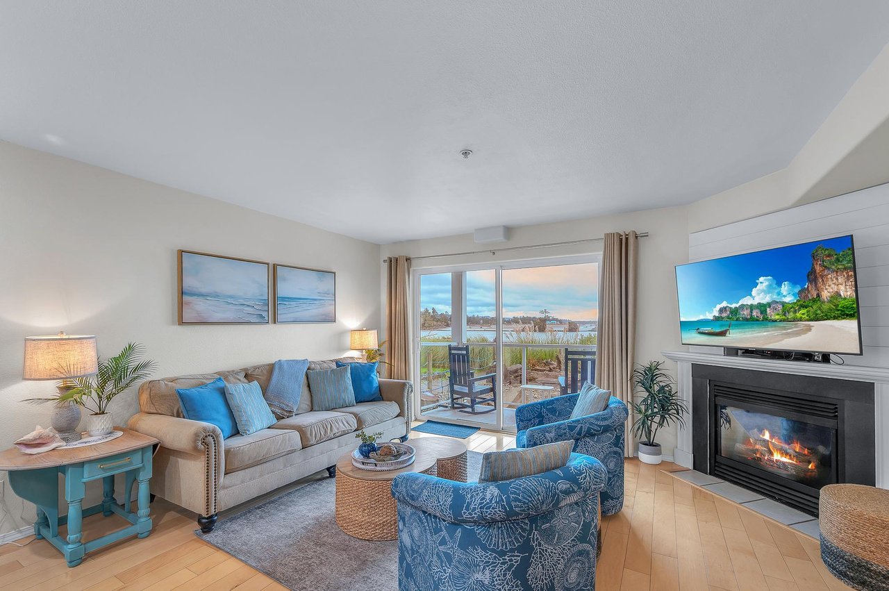 Unwind in this bright coastal living room with ocean views, cozy fireplace, and beachy decor perfect for your seaside retreat.