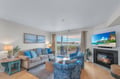 Unwind in this bright coastal living room with ocean views, cozy fireplace, and beachy decor perfect for your seaside retreat.