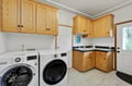 Your dedicated laundry room combines function with style, featuring modern appliances and ample oak cabinetry for all your storage needs.
