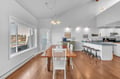 Gather around your spacious dining table where warm wood floors meet coastal charm, while natural light streams through windows.