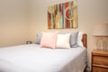 A cozy bedroom awaits, with soft bedding, playful throw pillows, and warm art that invites you to unwind after a day of exploring.