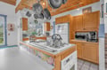 Your spacious kitchen awaits with warm wood cabinets, exposed beams, and everything you need to create memorable meals together.